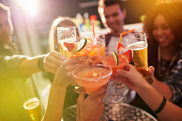 A group of people celebrating at a bar, illustrating the importance of creating a welcoming atmosphere in hospitality marketing.