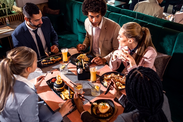 A busy restaurant with happy diners enjoying their meals.