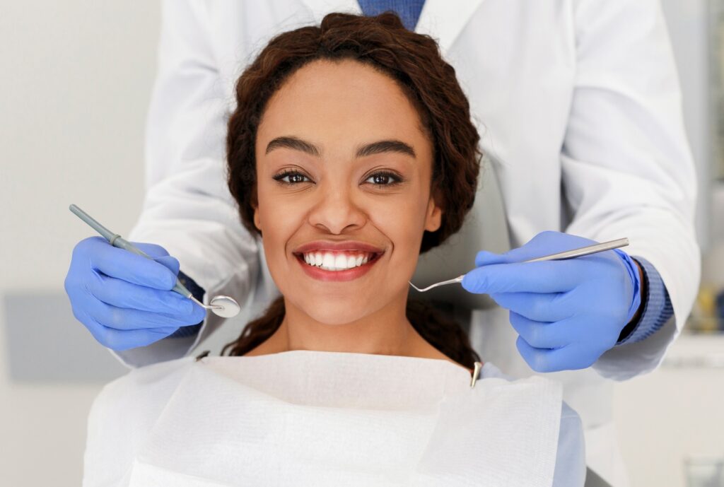 Cheerful african woman and dentist staying behind