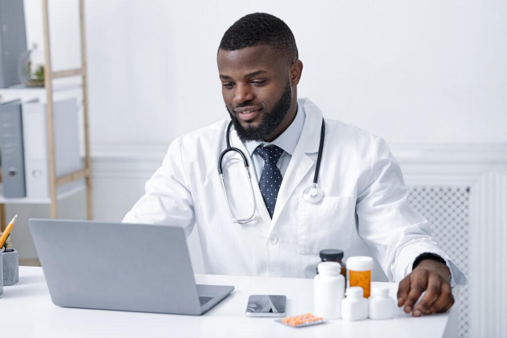 Concentrated african doctor checking on new pills