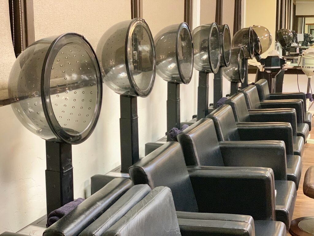 Row of empty Hooded hot hair dryer chairs at the salon beauty parlor
